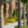 a sidewalk with trees and bushes